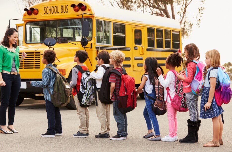 Children line up in front of bus