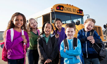 Young special ed kids in front of bus