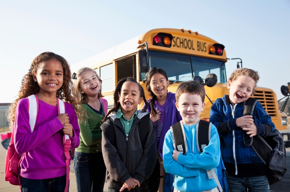 Young special ed children near schoolbus